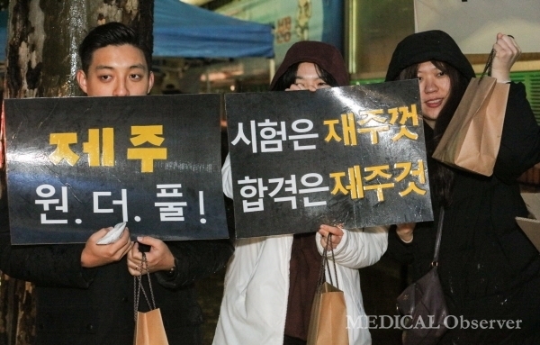 Jeju National University medical students cheer for senior candidates with hand-made pickets.