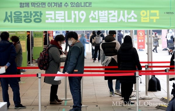 23일 서울시청 광장에 마련된 임시선별검사소를 찾은 시민들이 코로나19 검사를 받기 위해 줄을 서서 대기하고 있다.