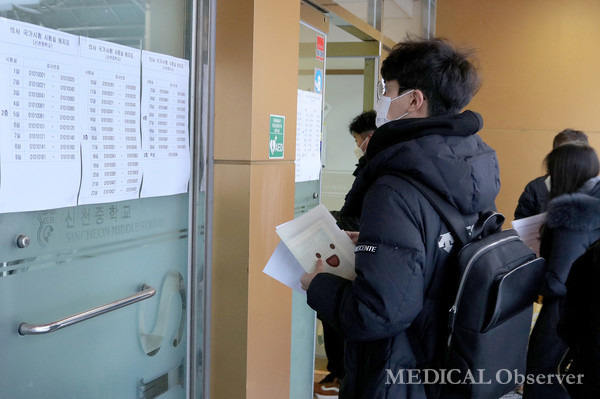제85회 의사 국가시험 필기시험이 치러진 서울 신천중학교 시험장에 수험생이 시험실 배치표를 확인하고 있다.
