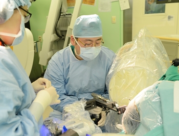 세브란스병원 신경외과 장원석 교수가 국내 최초로 개발된 뇌수술 보조 로봇장비인 카이메로를 이용해 환자의 뇌심부에 전극을 삽입하고 있는 모습.