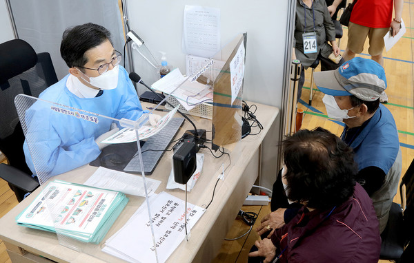 대한의사협회 이필수 회장이 25일 서울 도봉구 시립창동청소년센터에 마련된 코로나19 백신접종센터에서 예진 봉사를 하고 있다.