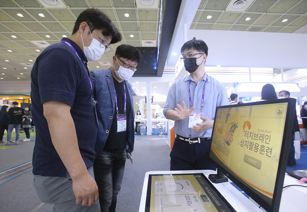 9일 서울 코엑스에서 열린 바이오 산업 국제 행사 '바이오 코리아 2021'에서 관람객이 전시관계자의 디지털 헬스케어 제품설명을 듣고 있다.