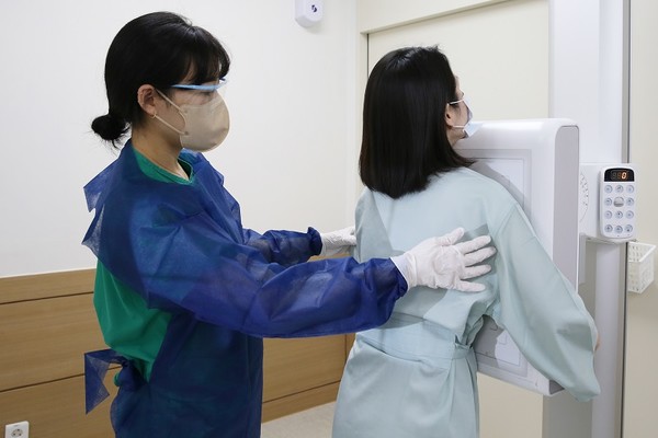 30대 여성 환자가 흉부 X-ray 검사를 촬영하고 있다.