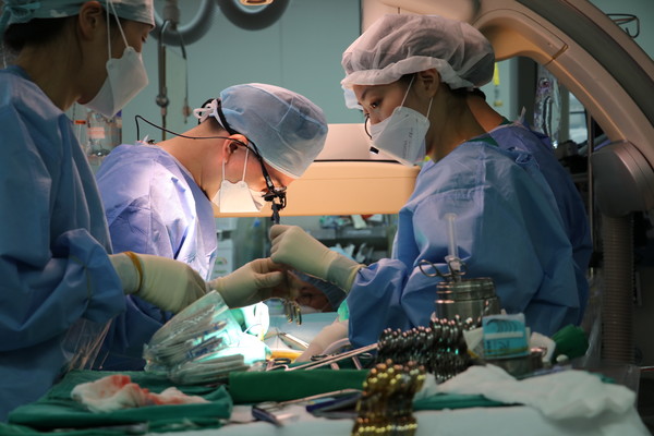 송석원 대동맥혈관센터장(심장혈관외과 교수)(가운데)이 E-vita OPEN NEO 장비를 통해 50번째 하이브리드 대동맥 수술을 시행하고 있다.