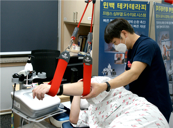 한림대성심병원 특수 도수치료실 전문물리치료사가 환자에게 슬링 치료와 고주파 장비를 이용한 도수치료를 실시하고 있다.