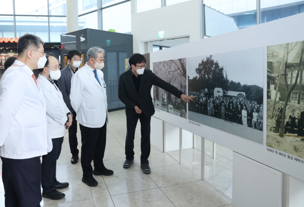 윤동섭 의료원장(오른쪽 두 번째)이 1일 에비슨 동상 사진 전시회에서 사진을 관람하고 있다.