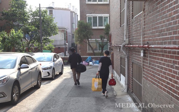 방문진료에 나선 서울신내의원 이상범 원장(좌측)과 김경미 간호과장(우측)이 환자의 집에 들어서고 있다.