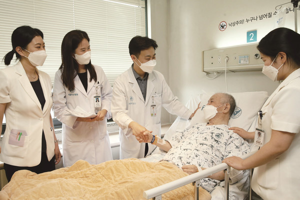 서울아산병원 시니어환자관리팀 의료진이 입원한 노년 환자를 방문해 치료 계획에 대해 설명하고 있다.