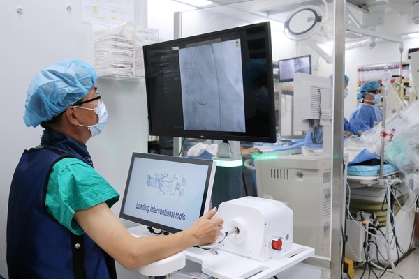 서울아산병원 심장내과 이승환(왼쪽), 김태오(오른쪽) 교수팀이 국산 로봇을 이용한 관상동맥중재술을 국내 최초로 시행하고 있다.