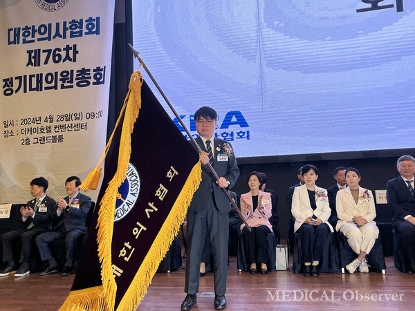 28일 양재 더케이호텔에서 열린 제76차 정기대의원총회에서 임현택 당선인이 의협 회기를 흔들고 있다. 이날 임 당선인은 의대 증원 저지를 위해 강력한 대정부 투쟁을 예고하며 정부를 향해 전면 백지화를 요구했다.