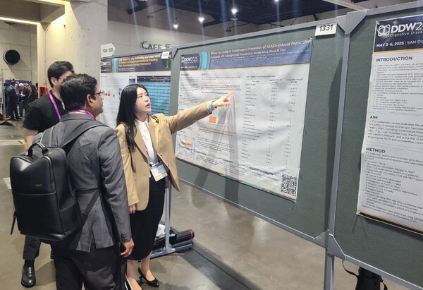 해외 의료진(왼쪽)이 펙수클루(펙수프라잔)의 NSAIDs 유도 소화성궤양 예방 임상연구 결과를 보고 있다.